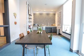 A dining room with a wooden table and chairs.